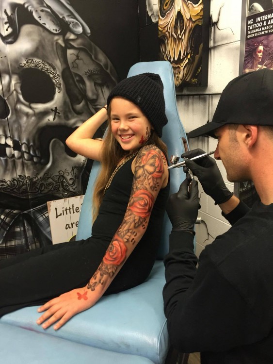 Lloyd tattooing a young girl