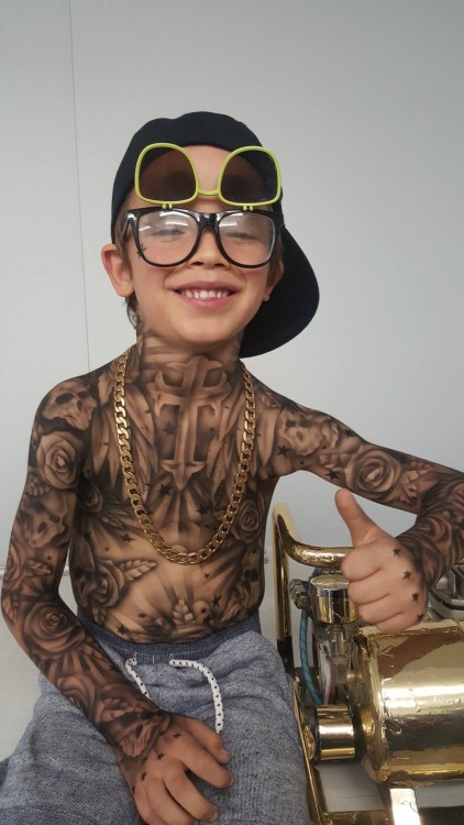 Young boy shows off his new tattoos