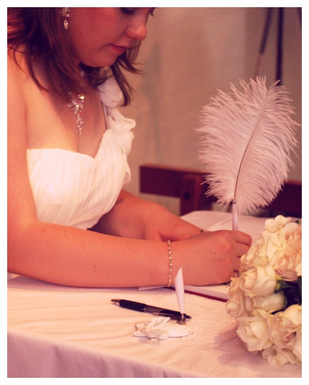 bride writing on a table using a feather pen
