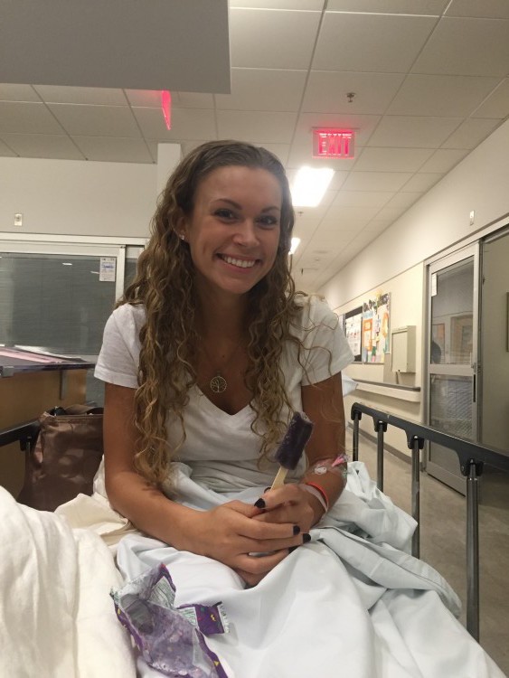 young woman sitting up smiling in hospital bed