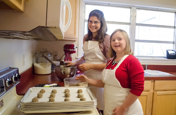 In a photo provided by Elise Sampson, Carolyn Sampson and a helper prepare Reason to Bake cookies.