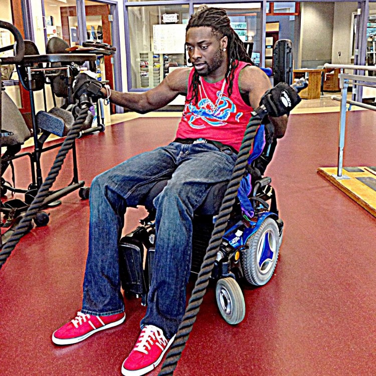 Nnaka works out in the gym while sitting in his wheelchair