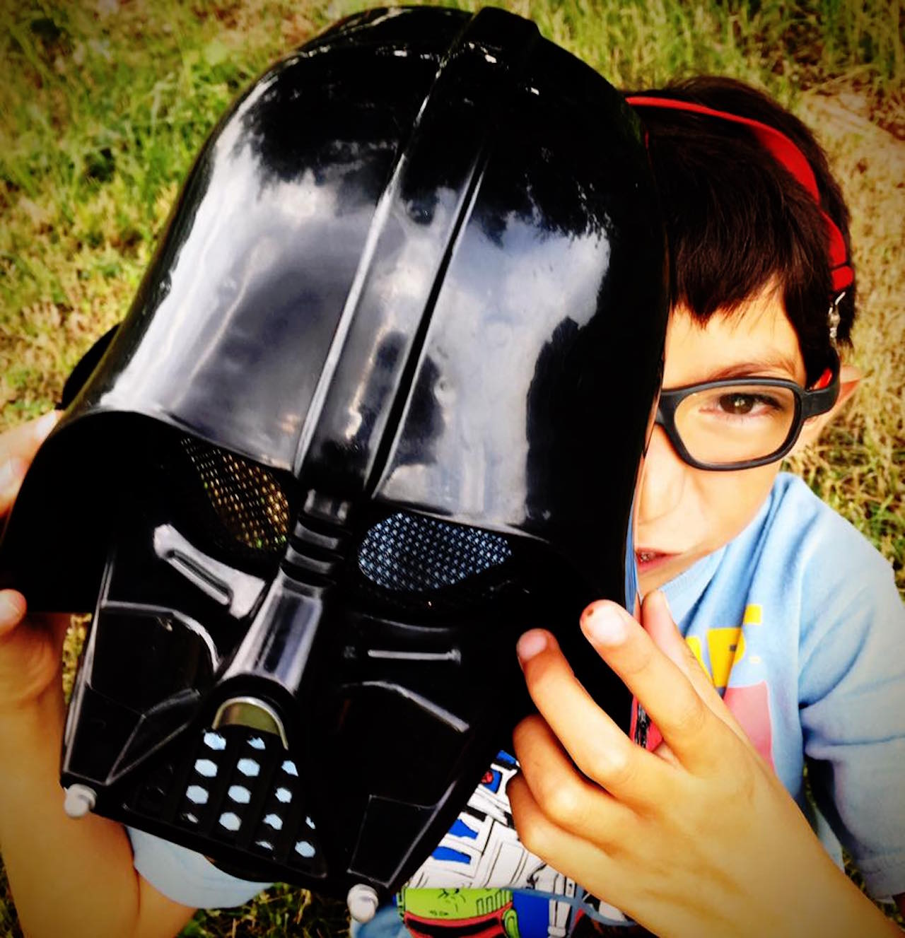 boy holding a darth vadar mask