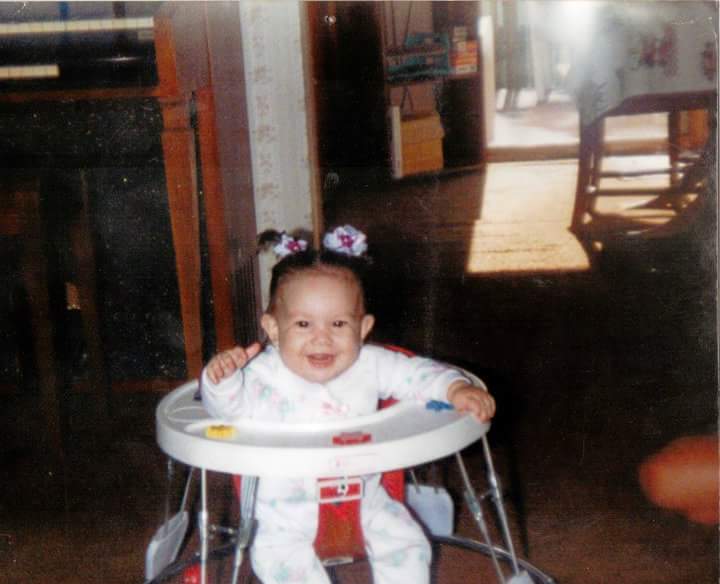 Cami sitting in a highchair smiling