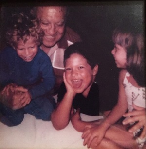 An old photo of the author, his brother, his sister and his grandfather laughing.