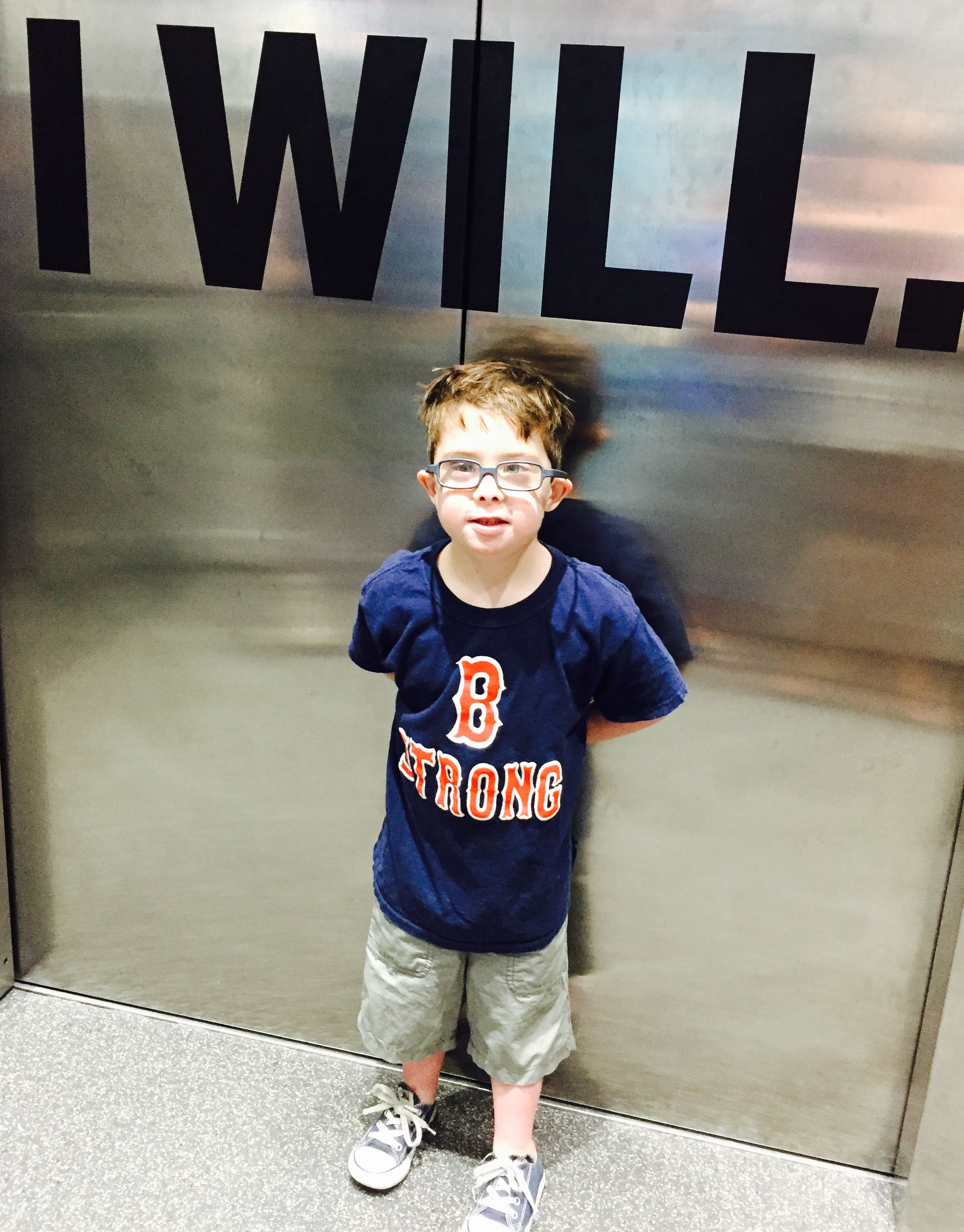 The author's son standing in front of a mirrored wall that says "I Will"