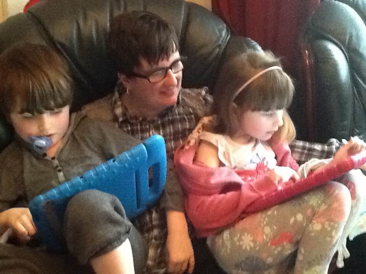 mom reading to her two autistic children on ipads