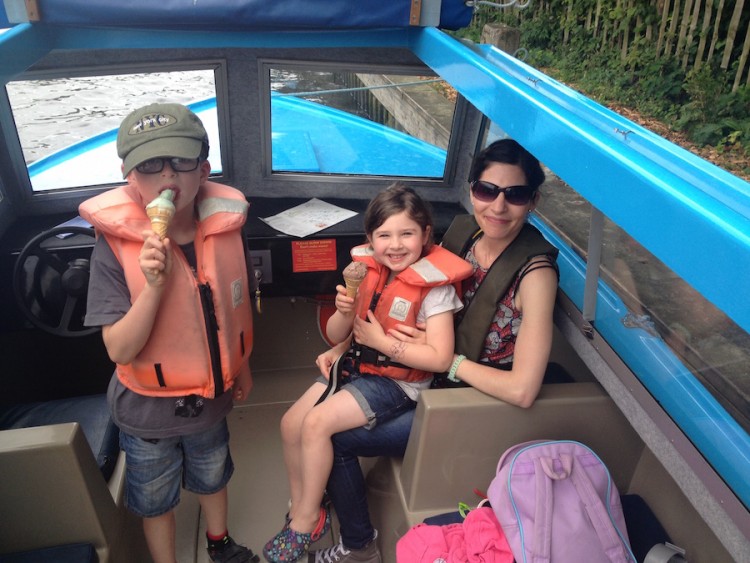 woman sitting on a boat with two young kids