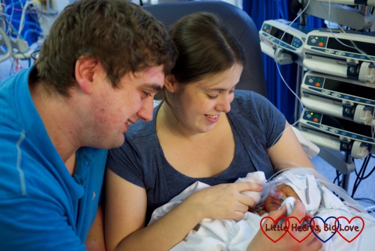 parents holding their newborn baby