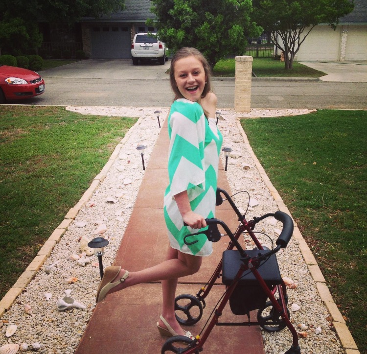 The author standing with a walker on a path leading to a residential street