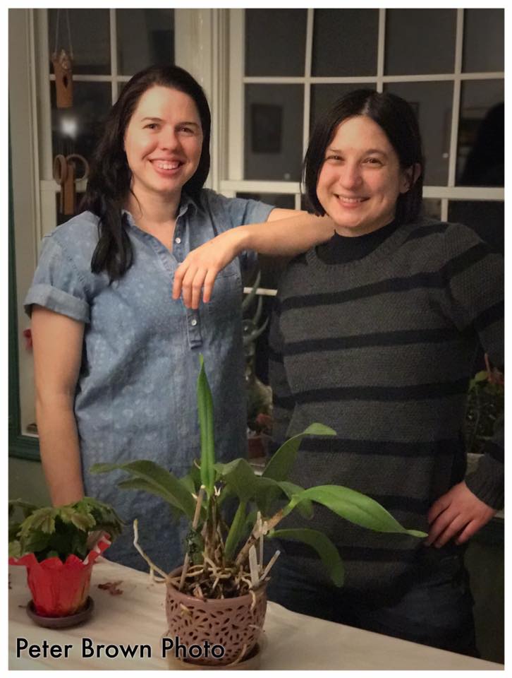 The author and her friend this year, smiling and standing indoors near window