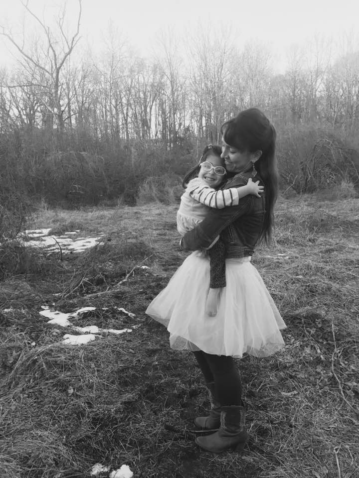 mom holding daughter smiling