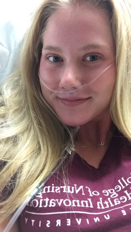 Woman with oxygen tube in nose, smiling.
