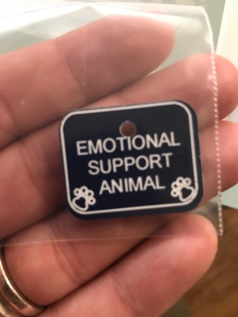 emotional support animal tag in person's hand
