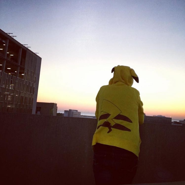 woman standing on a balcony watching the sunrise