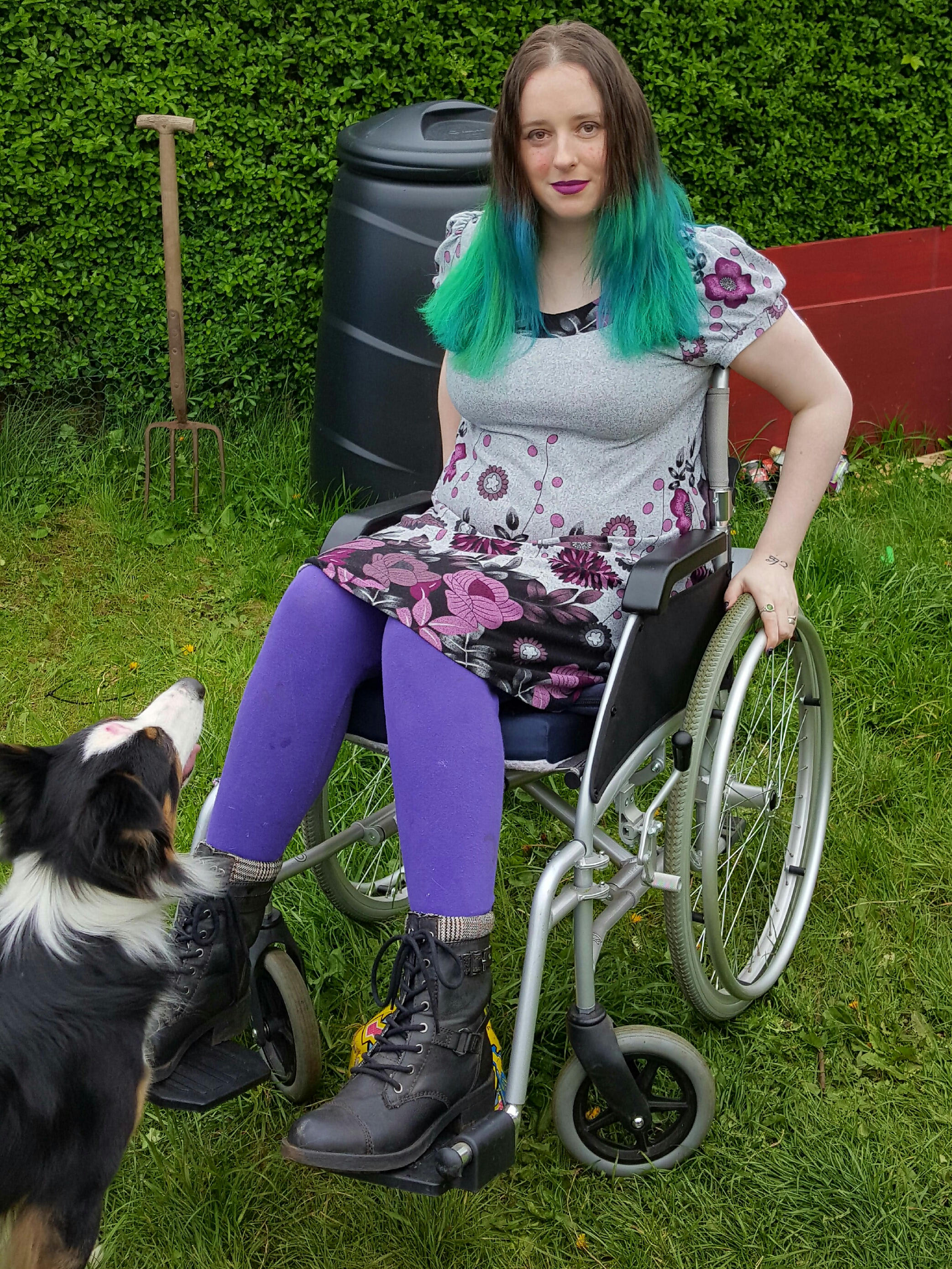 woman sitting outside in a wheelchair next to a dog