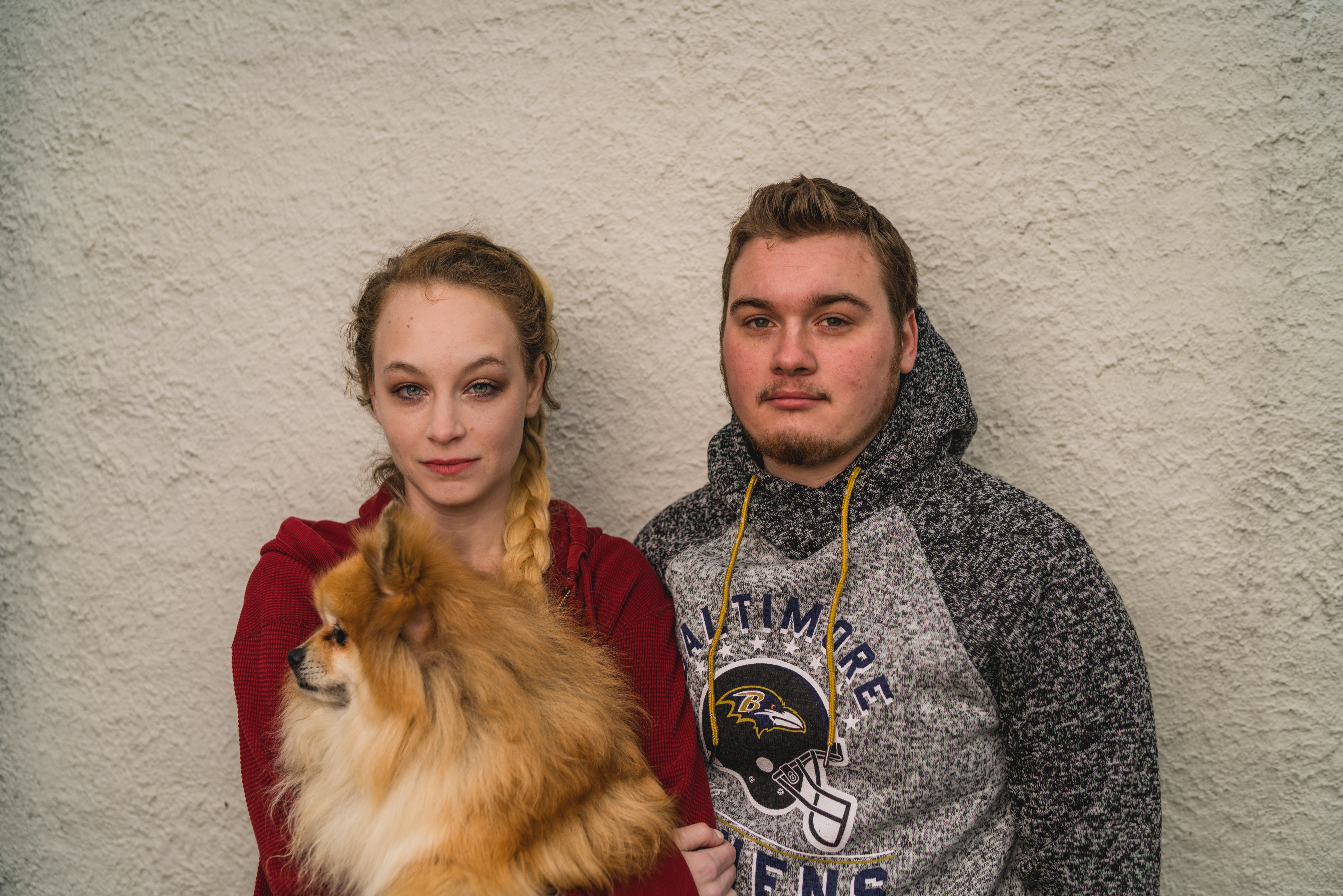 woman holding dog, standing next to boyfriend