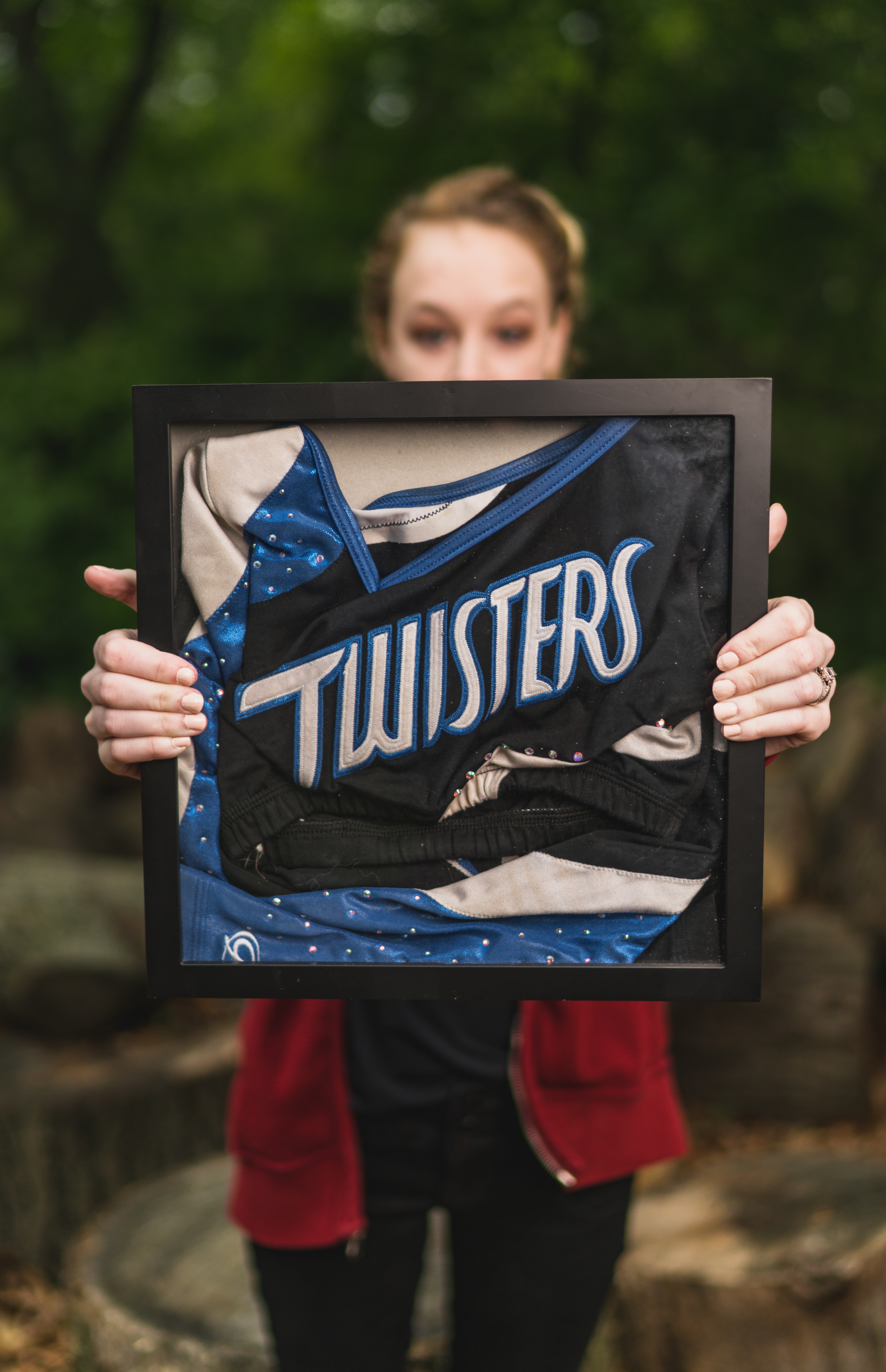 woman holding image of cheerleading uniform