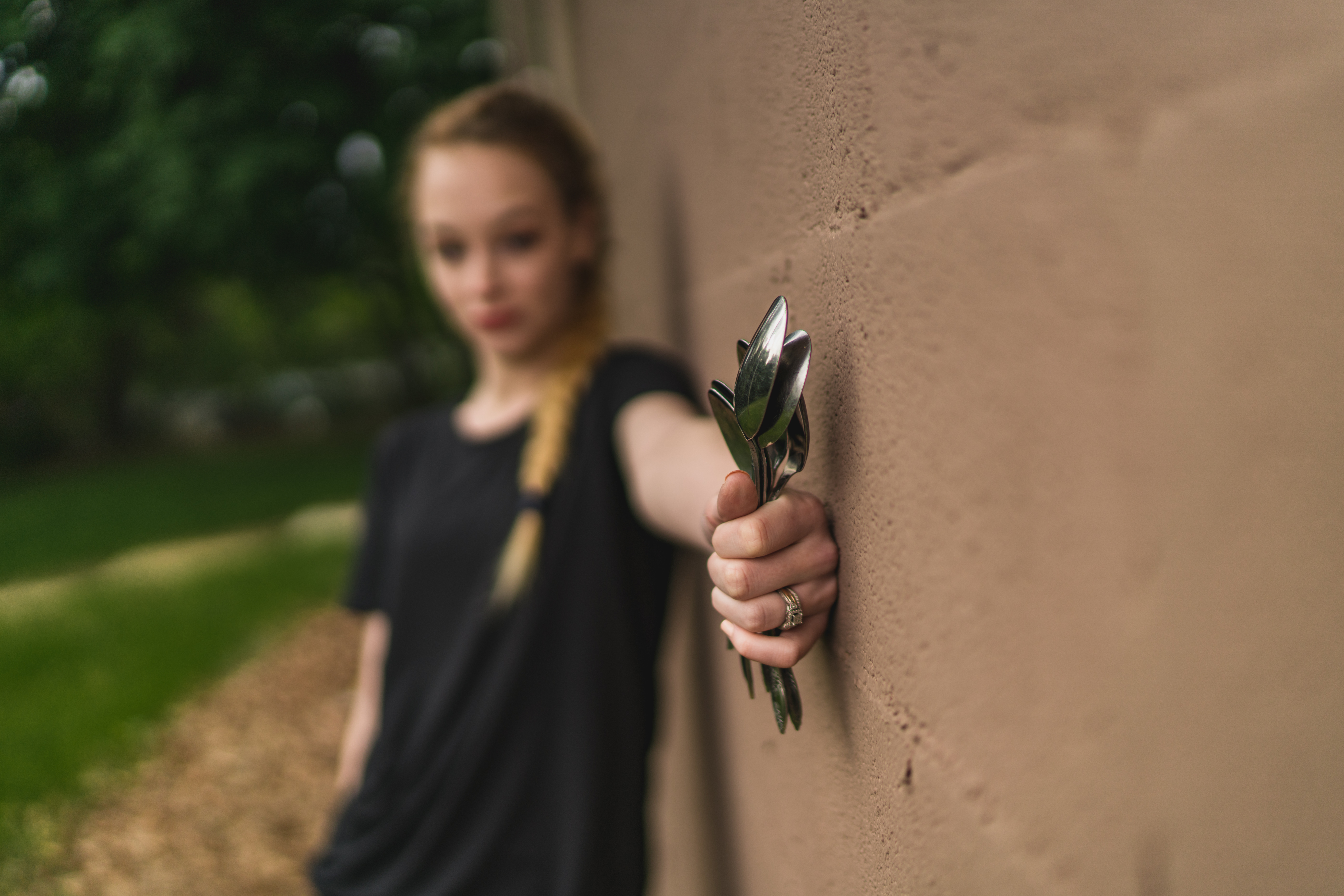 woman holding spoons against a wall