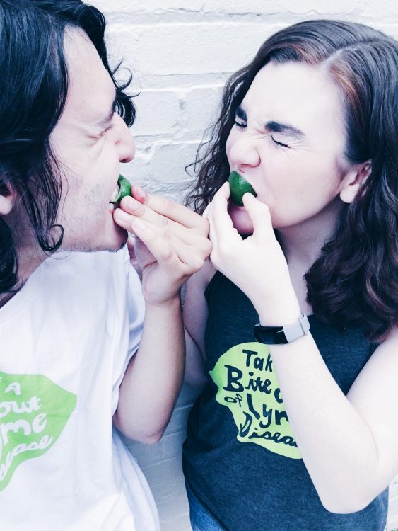 woman and man biting into limes