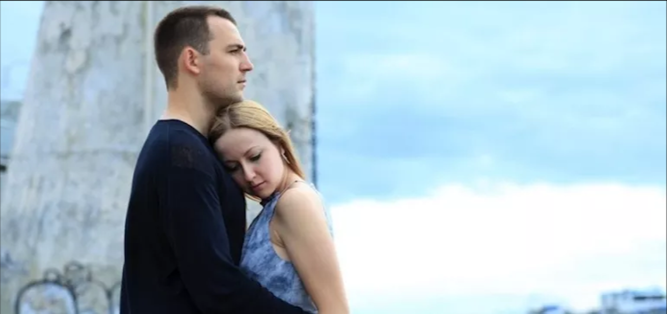 man and woman holding each other and standing outside