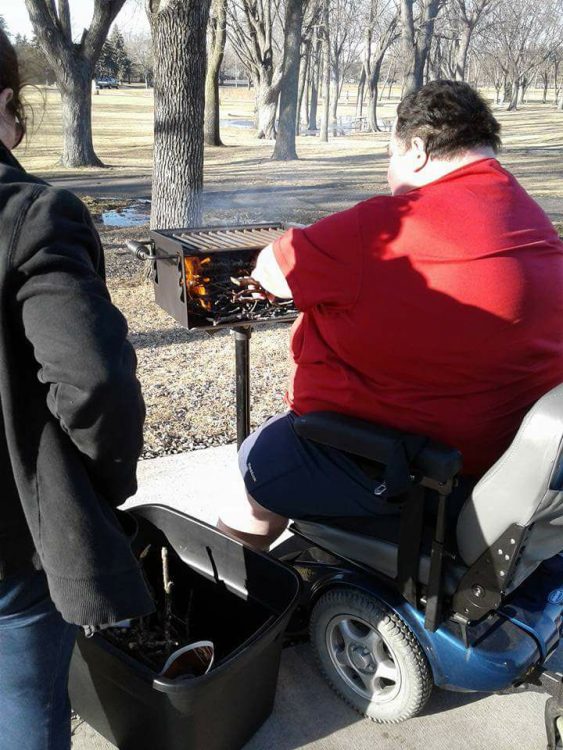 man in a wheelchair cooking on the grill