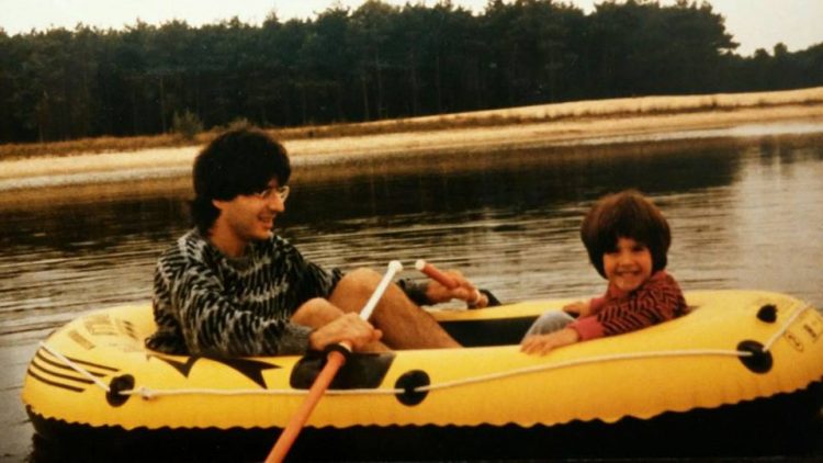 dad and young daughter in a raft on a lake