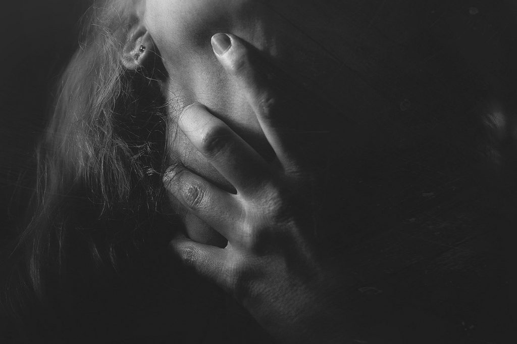 Black and white image of photographer's representation of how depression affects her voice, hand clutched to throat