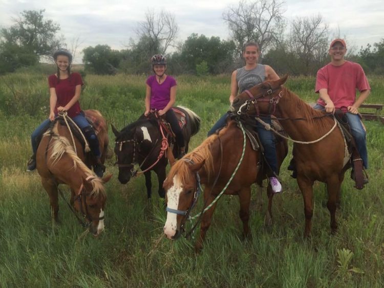 family of four riding on horses