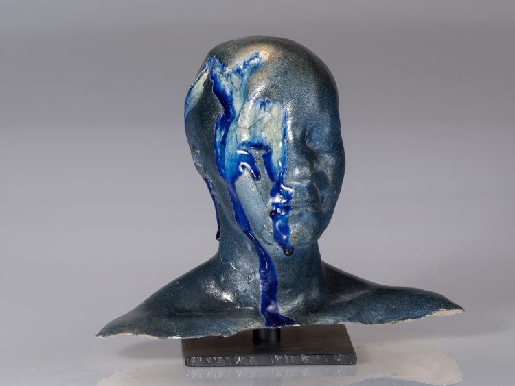 ceramic head with blue paint running down the side