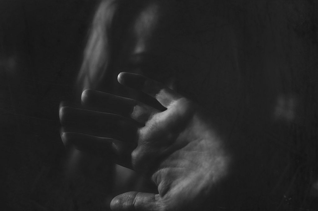 Black and white image of photographer's representation of how depression affects her connections, image of woman pushing viewer away