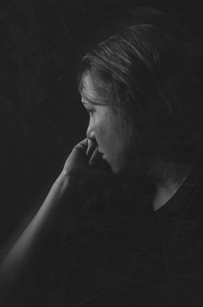 Black and white image of photographer's representation of how depression affects her joy resting head on hand