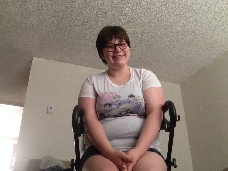 photo of a woman smiling and sitting in her wheelchair