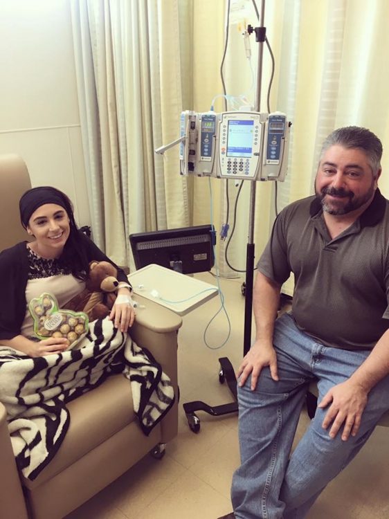 woman receiving an infusion and smiling next to a man