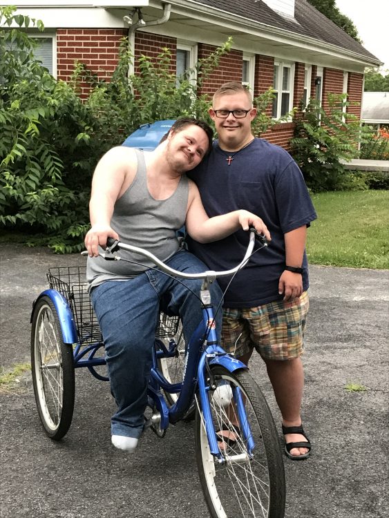 Charley on the new bike with Trevor standing by his side.