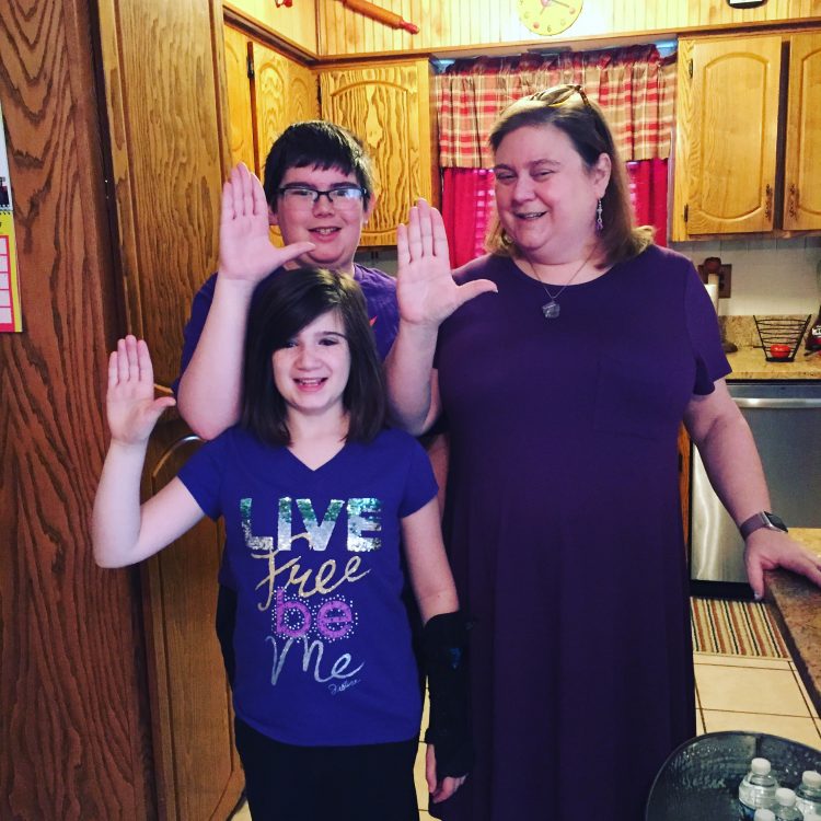 The writer with her two children, making the same hand gesture.