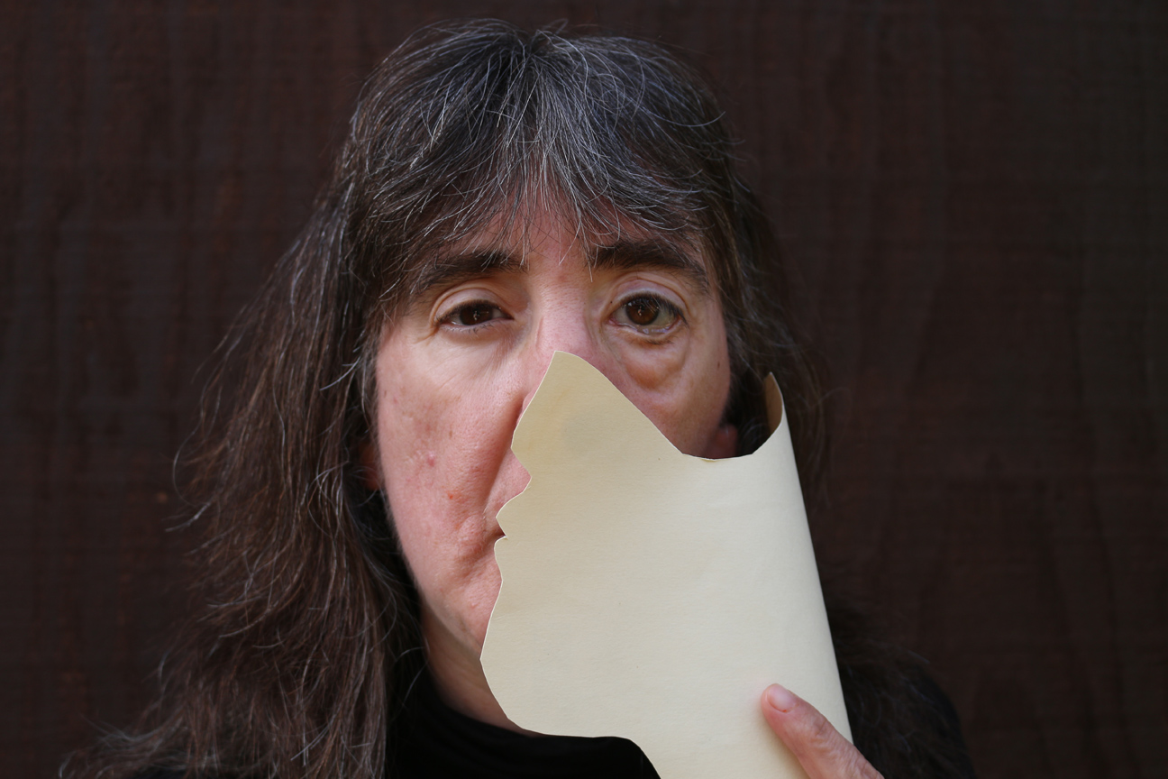 the author, holding a paper over one side of her face