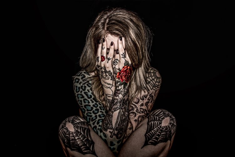 woman with tattoos doing a photo shoot to represent her pain from arthritis