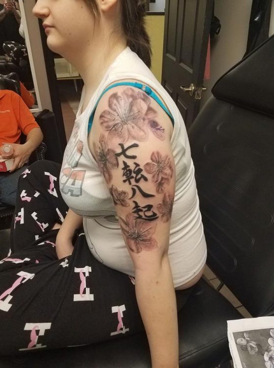 chinese symbols and flowers tattoo on arm