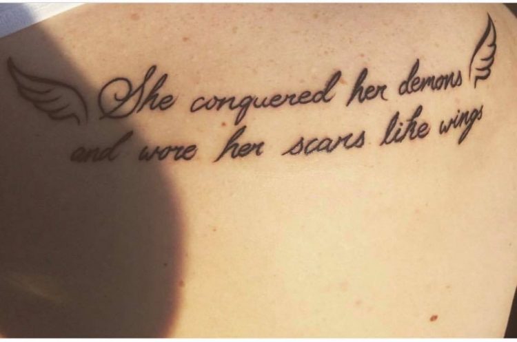 conquered demons quote and wings tattoo