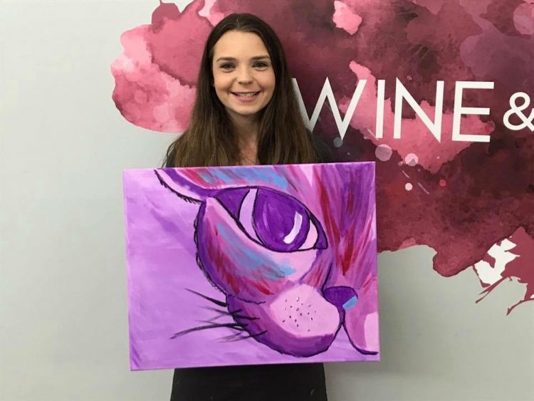 woman smiling and holding a painting she made