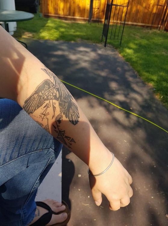 shattering raven tattoo on arm