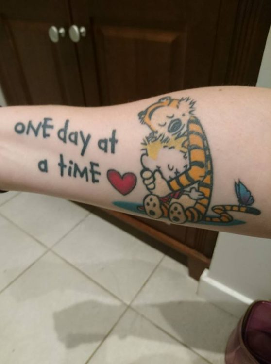 calvin and hobbes tattoo that says 'one day at a time'