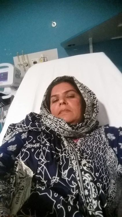 woman wearing a hijab and lying in a hospital bed