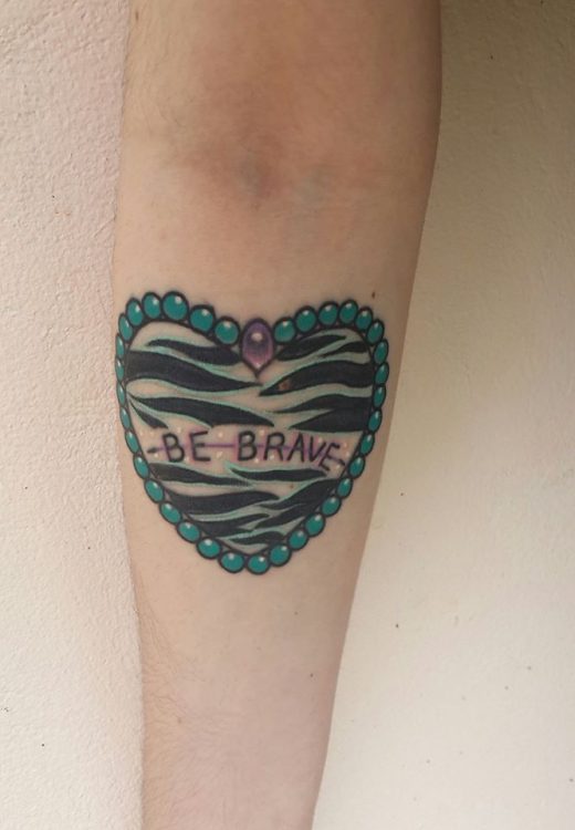 tattoo of heart with zebra pattern that says 'be brave'