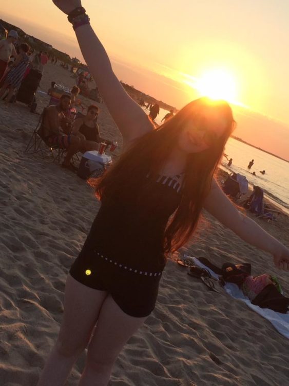 woman standing on the beach at sunset