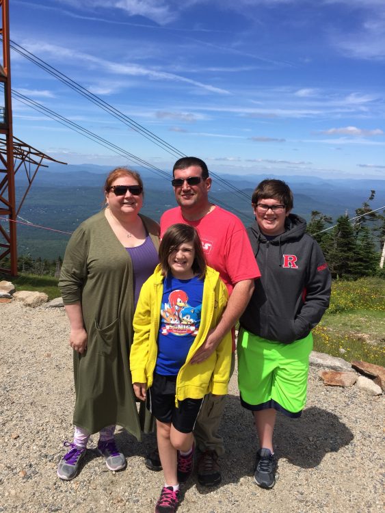 family standing together on a mountain