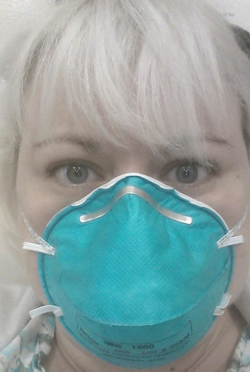 A woman wearing a medical face mask.