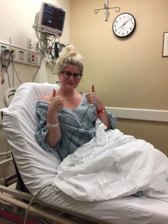 woman giving a thumbs up from her hospital bed