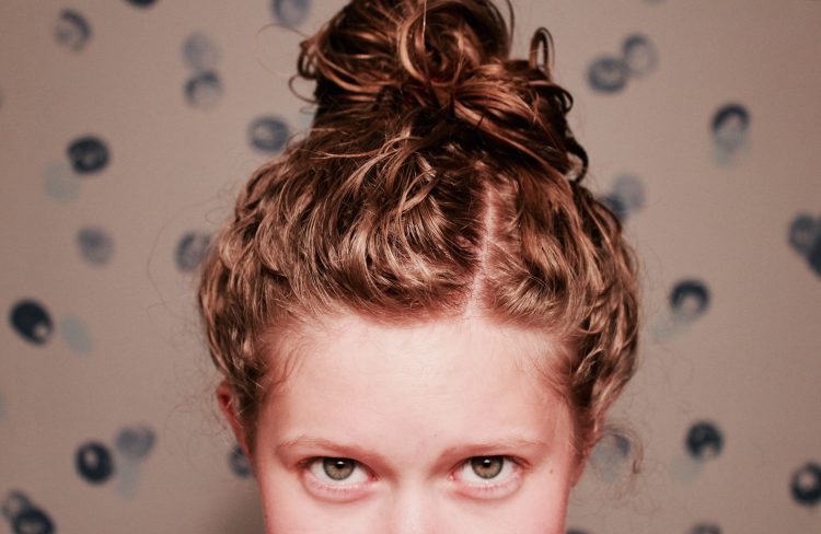 photo of woman's eyes with her hair in a bun